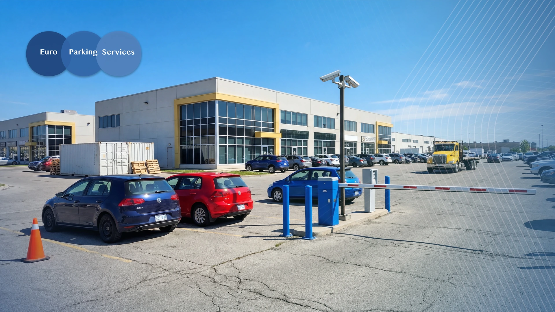 Commercial car park outside a modern industrial building, showing parked cars, an ANPR barrier system with cameras