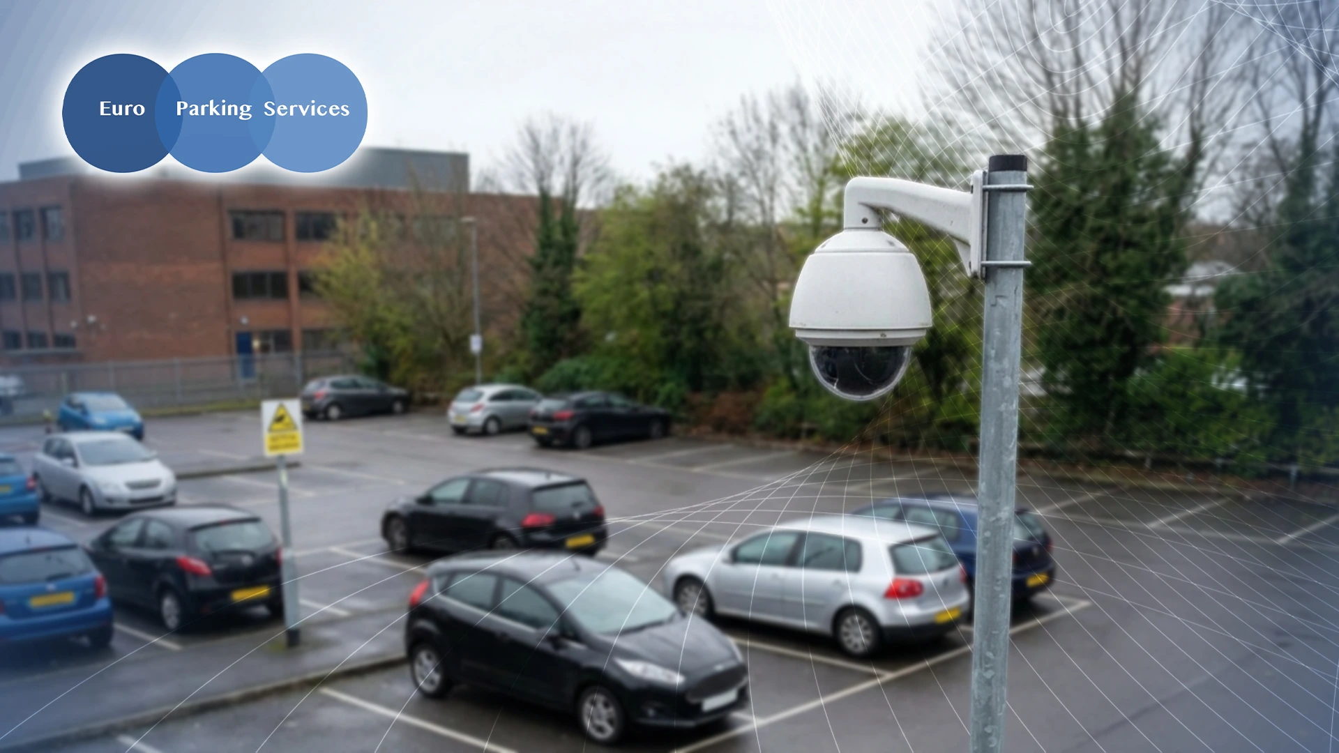 CCTV camera monitoring a car park with multiple parked vehicles.